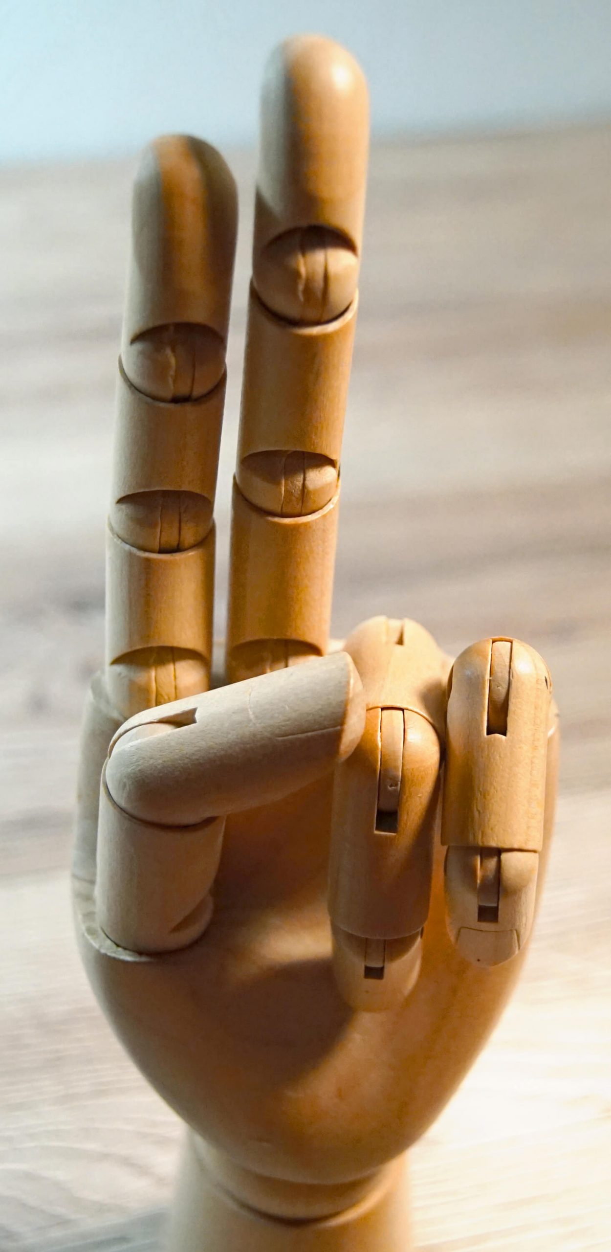 Werbung in Sozialen Medien - Holzhand hält zwei Finger hoch