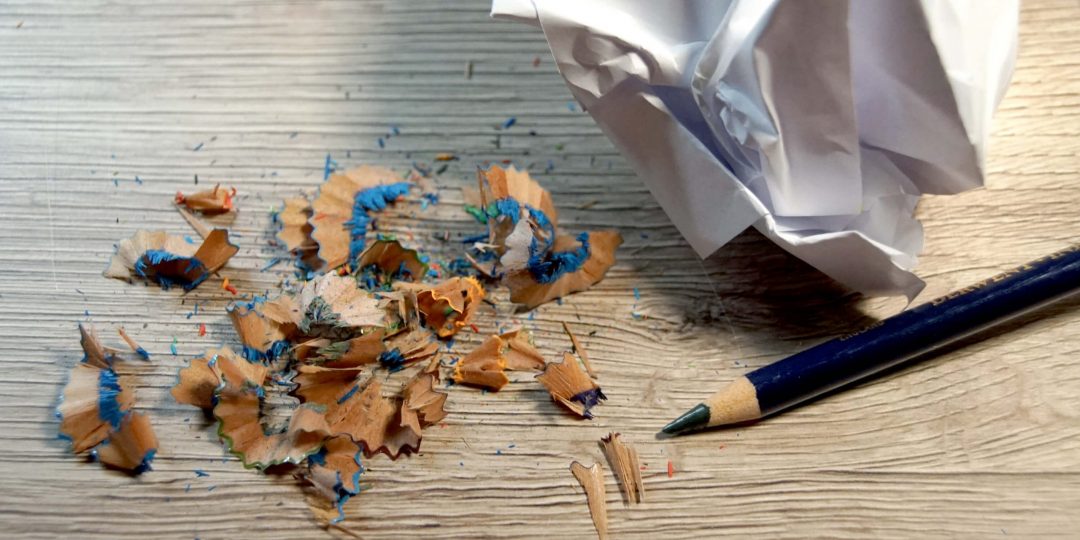 Spitzerreste vom Buntstift und zerknülltes Papier