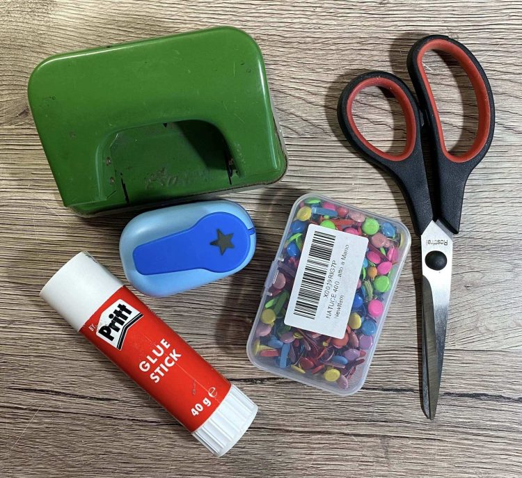 Bastelmaterial: Locher, Klebestift, Schere, Rundkopfklammern