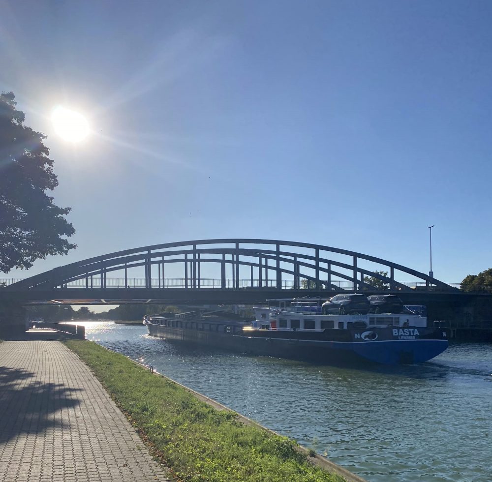 Sonnenlicht blendet und ein Schiff fährt auf dem Kanal